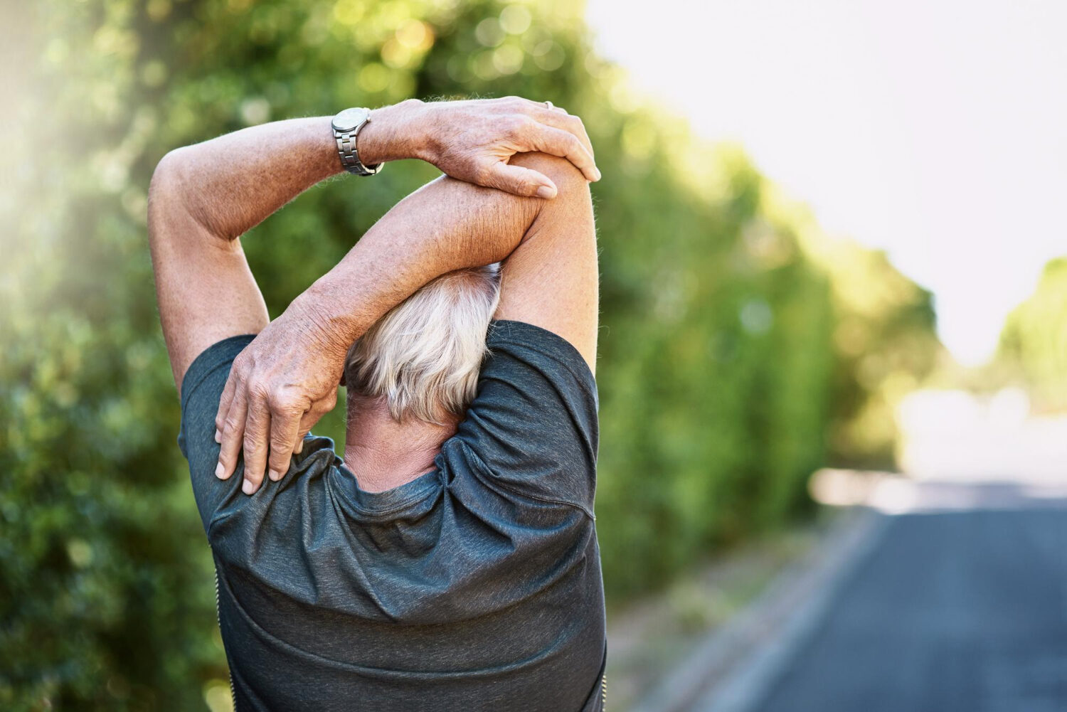 An older adult stretching their back to relieve tension, illustrating the question Is Thoracic Spine Surgery Dangerous and highlighting recovery and mobility in seniors.