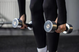 Person performing dumbbell strength training exercises to improve muscle conditioning, joint stability, and long-term injury prevention.