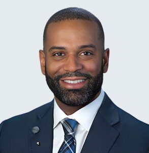 Professional headshot of Dr. Jason Billinghurst, MD, wearing a navy suit and tie with a friendly smile against a light gray background.