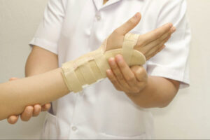 Healthcare professional supporting a patient’s wrist brace during recovery and rehabilitation after carpal tunnel release surgery.