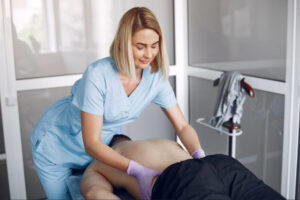 Healthcare professional assisting a patient during post-operative hip rehabilitation and mobility recovery after hip arthroplasty surgery.