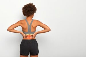 Person experiencing lower back pain and spinal discomfort commonly associated with disc degeneration