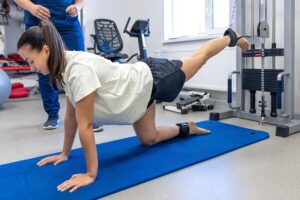 Patient performing supervised rehabilitation exercises during physical therapy after microdiscectomy surgery