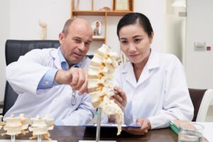 Spine specialists reviewing spinal anatomy and surgical planning before artificial disc replacement surgery