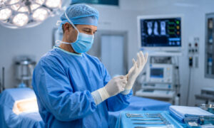 Orthopedic surgeon preparing for elbow surgery in a modern operating room before performing a cubital tunnel release procedure.