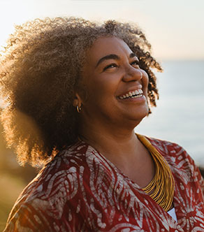 A woman who had total joint replacement in Boynton Beach smiles brightly.