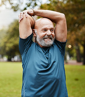 A man who underwent total joint arthroplasty in Boynton Beach stretches in the park.